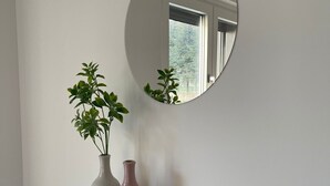 A mirror on a wall with two vases on a shelf below. - TaMo Lovely apartment (Fisciano)