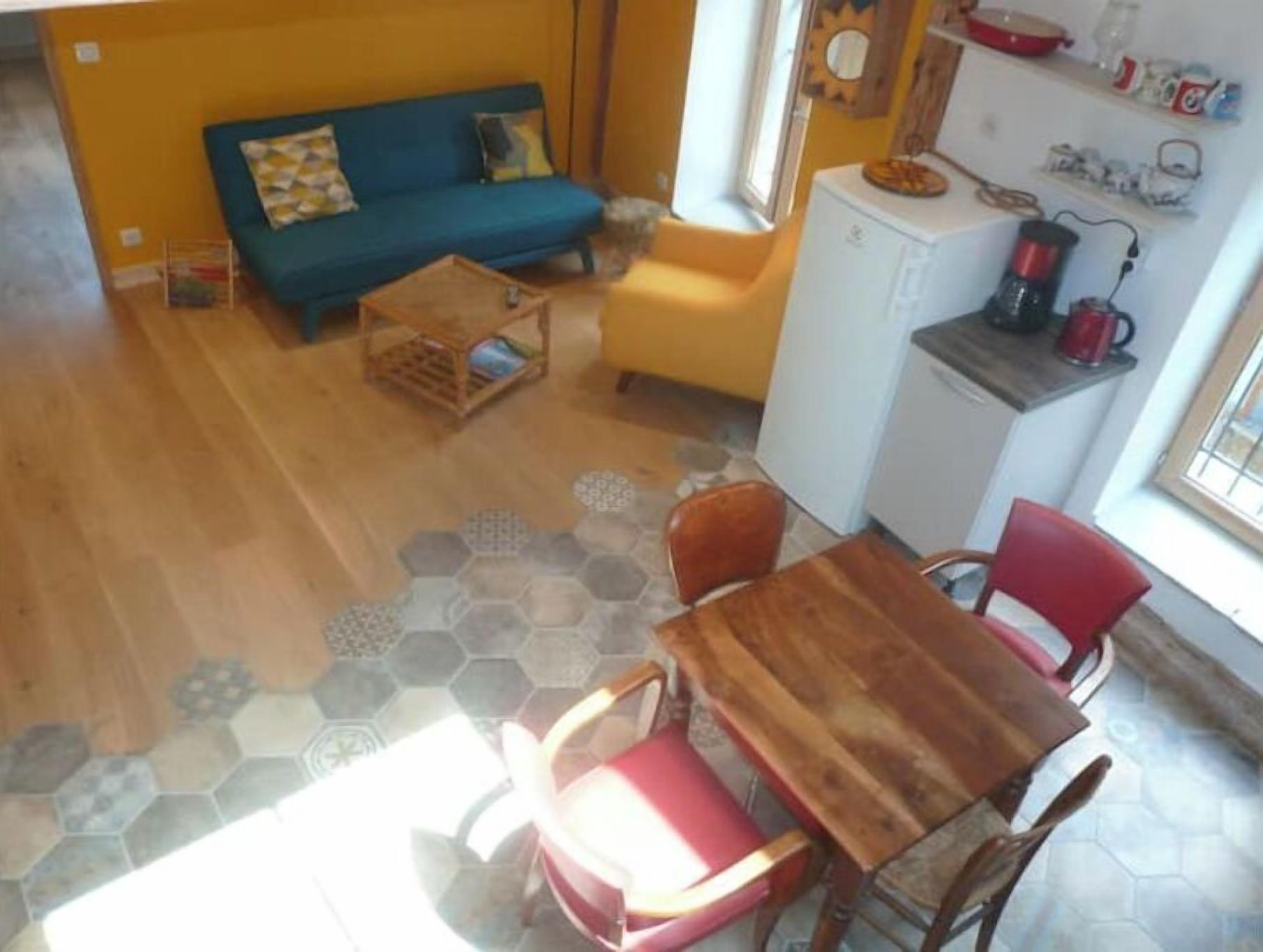 A compact living space with a sofa, a small dining table, and chairs.