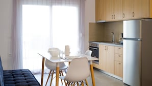 Una cocina moderna con armarios de madera, un refrigerador de acero inoxidable y una zona de comedor con mesa y sillas.
