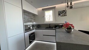 Eine moderne Küche mit Backofen, Spüle und Fenster.