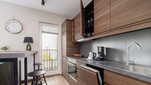 Une cuisine moderne avec des meubles en bois, un évier en acier inoxydable et un four encastré.