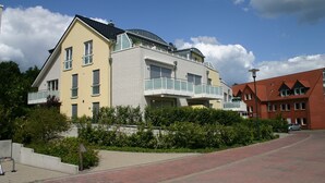 Kerrostalo, jossa on useita kerroksia ja parveke toisessa kerroksessa.