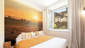 Een slaapkamer met een bed, een nachtkastje, een raam met gordijnen en een muurschildering van een landschap.