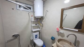 Een douche, designer toiletartikelen, een haardroger, pantoffels