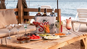Ein Holztisch mit Getränken, Snacks und einer Flasche Absolut Vodka.