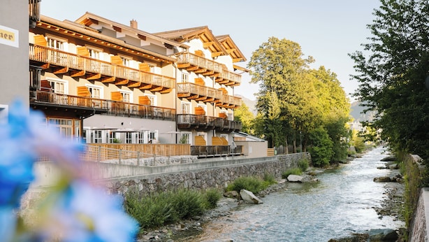 A multi-story hotel with balconies overlooking a river.