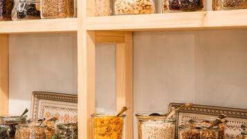 A storage area with multiple shelves containing glass jars filled with various grains and seeds.