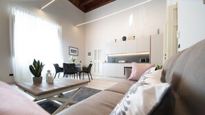 Ett modernt vardagsrum med en soffa, ett soffbord och en matplats med stolar.