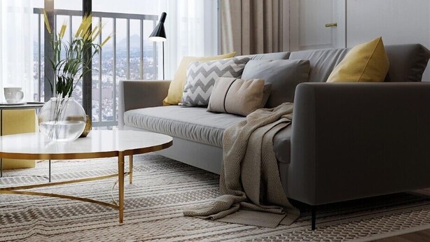 Ein modernes Wohnzimmer mit grauem Sofa, einem runden Couchtisch und Blick auf die Stadt durch große Fenster.