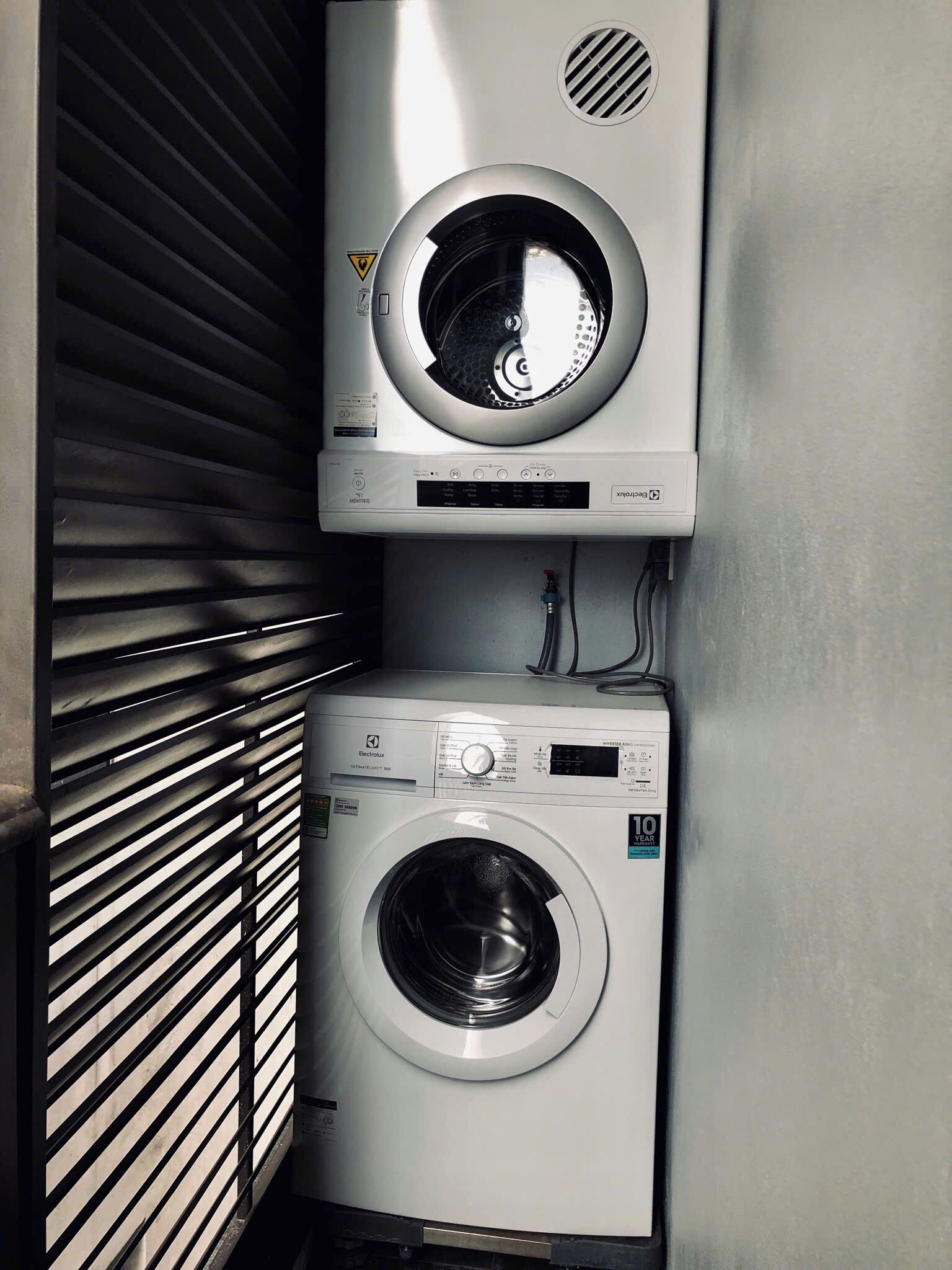 A compact laundry room with a front-loading washing machine and a stacked dryer.