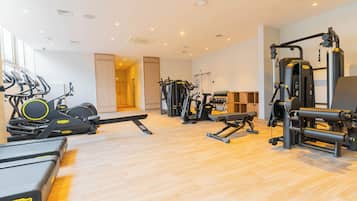 Uma academia com esteiras, elípticos e equipamentos de musculação.