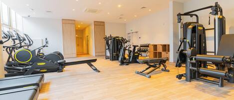 A gym with treadmills, elliptical machines, and weightlifting equipment.