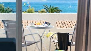A balcony with a table, chairs, and a view of the sea. - Apartamentos Sivella (Pollenca)