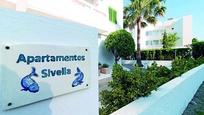A sign for 'Apartamentos Sivella' with a depiction of two fish. - Apartamentos Sivella (Pollenca)
