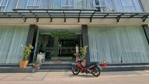 A multi-story building with large windows and a covered entrance area. - osaka hotel batam (Batam)