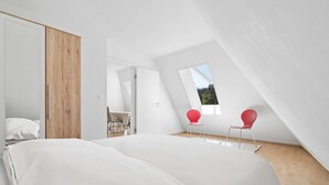 Un dormitorio moderno con una cama grande, un armario de madera y un tragaluz.