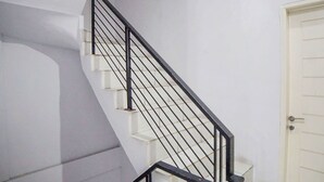 Un escalier avec des rampes noires et des marches blanches.