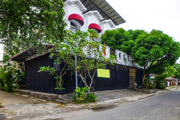 A building with a black gate, a yellow sign, and a red awning.