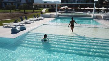 Una piscina al aire libre de temporada, sombrillas