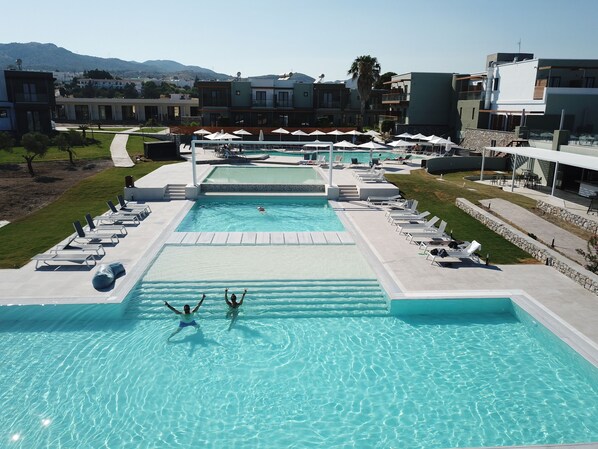 Una piscina al aire libre de temporada, sombrillas