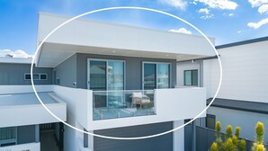 A modern two-story residential building with large windows, a balcony, and a flat roof. - Coastal Breeze 12a - Kingscliff Studio (Kingscliff)