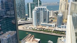 Um edifício alto com vista para uma marina e outros edifícios.