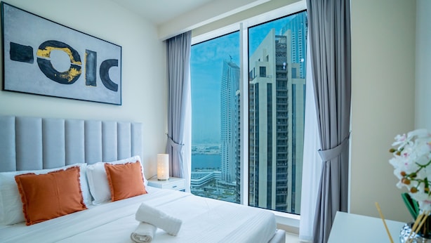 Habitación de hotel con una cama grande, vistas a edificios altos y un diseño moderno.