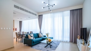 Una sala de estar moderna con un sofá modular, una mesa de centro de vidrio y un televisor de pantalla plana.