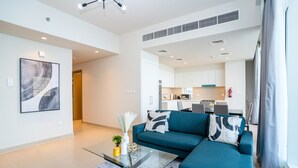 Una sala de estar moderna con un sofá color aguamarina, una mesa de centro de vidrio y un cuadro abstracto contemporáneo.