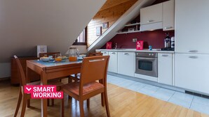 Una cocina moderna con armarios blancos, una mesa de comedor de madera y una zona para desayunar.