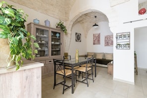 Enjoy meals in a cozy dining area with a glass-top table and comfortable seating for four.