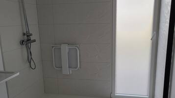 Moderni kylpyhuone, jossa on suihku, wc ja pesuallas.