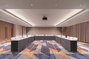 A conference room with a long table, white chairs, and a projector on the ceiling. - Ji Hotel Guangzhou Tianhe Sports Center (Guangzhou)