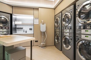 A laundry room with multiple washing machines, a drying machine, and a water heater. - Ji Hotel Guangzhou Tianhe Sports Center (Guangzhou)
