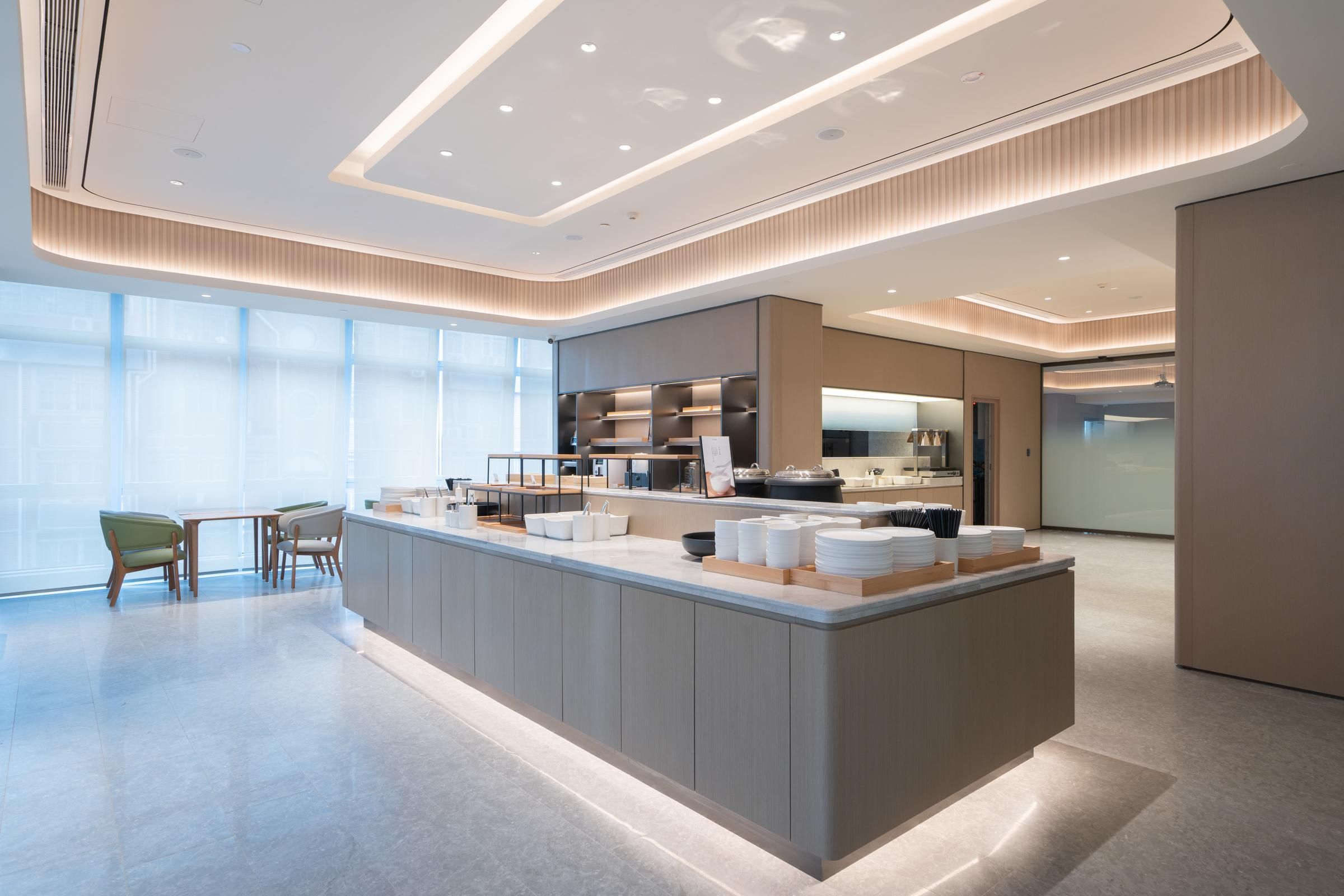 A modern hotel lobby with a central island, seating area, and large windows.