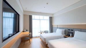 A hotel room with two beds, a desk, a chair, and a large window. - Ji Hotel Guangzhou Tianhe Sports Center (Guangzhou)