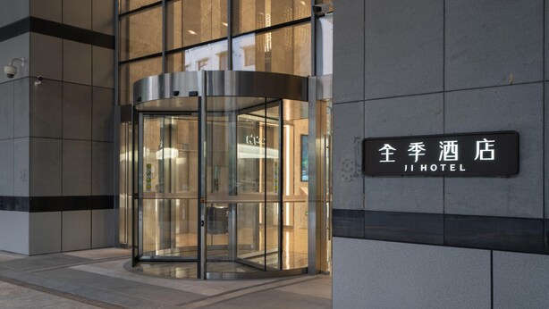 A hotel entrance with a revolving door and a sign reading "JI HOTEL". - Ji Hotel Guangzhou Tianhe Sports Center (Guangzhou)