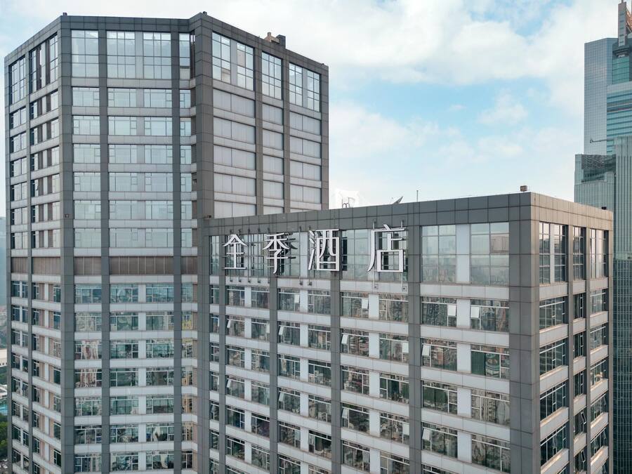 A modern high-rise building with multiple floors and large windows.