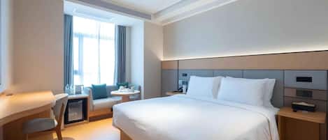 Een moderne hotelkamer met een groot bed, een bureau en een stoel.