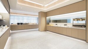 A modern kitchen with a central island, built-in appliances, and a large window providing natural light. - Ji Hotel Guangzhou Tianhe Sports Center (Guangzhou)