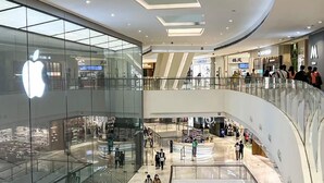 A multi-level shopping mall with glass storefronts, including an Apple store, and a central open space with a glass railing. - Ji Hotel Guangzhou Tianhe Sports Center (Guangzhou)