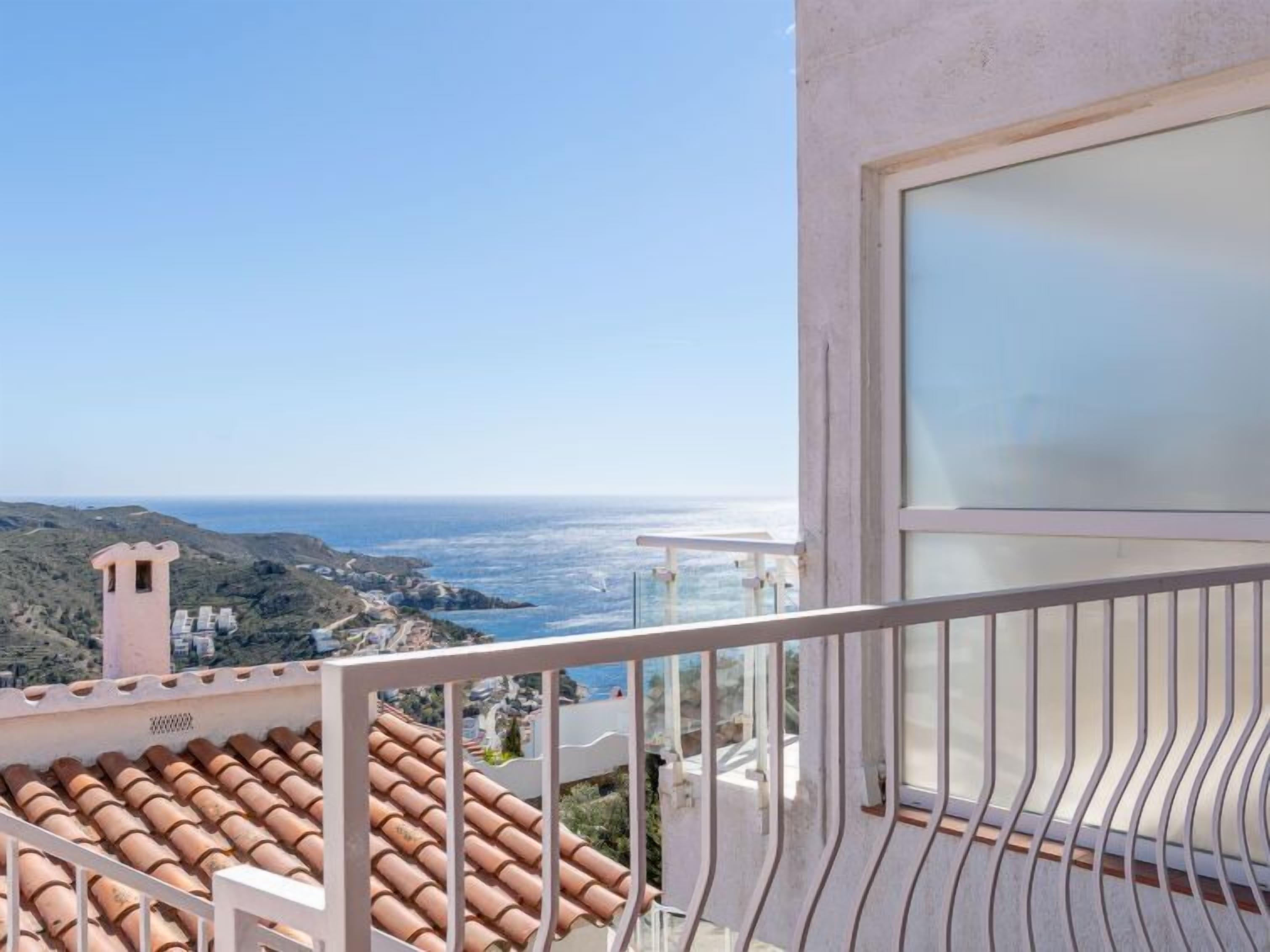Un balcon orné de carreaux de terre cuite, offrant une vue sur la côte.