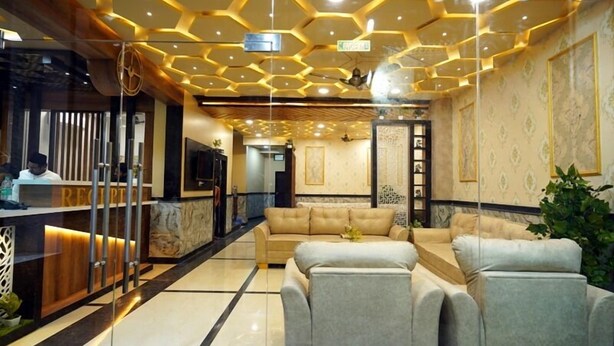 A lobby with a reception desk, a sofa, and a decorative ceiling. - Hotel Alishaan (Ajmer)