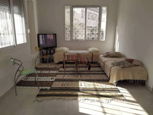 Cozy living space with a sofa, small table, and mounted TV, offering a comfortable seating area.