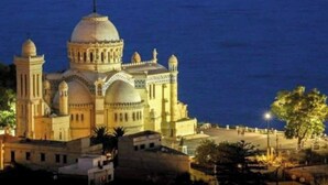 A large, historic building with multiple domes and towers, likely a cathedral or mosque, with a clear view of the surrounding area and a body of water in the background. - Great studio in El-Biar (Algiers)