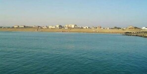 Enjoy a serene beach experience with a clear view of the ocean and surrounding landscape.