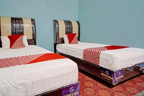 Two beds with striped headboards, white bedsheets, and red and white patterned pillows. - Hotel O Adela (Sibarani Nasampulu)