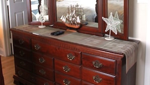 A wooden dresser with multiple drawers and a mirror above it. - Bayfront canal side condo (Rockport)