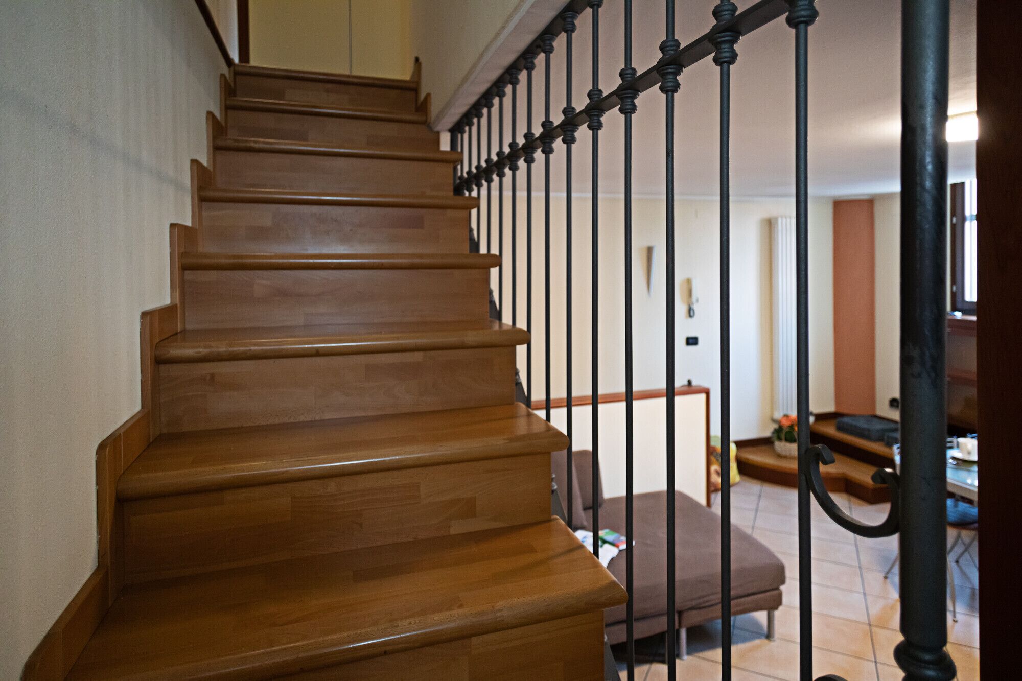 A wooden staircase with black balusters leading to a landing.