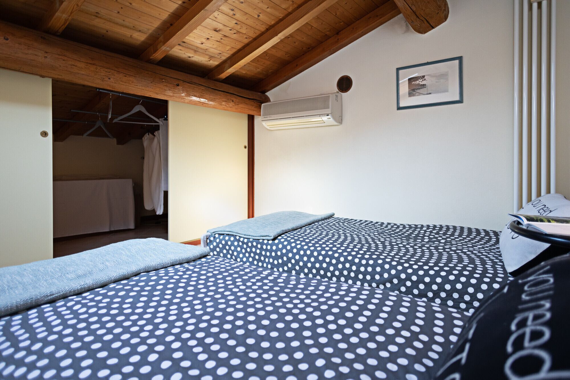 A bedroom with a bed, a window, and an air conditioning unit.